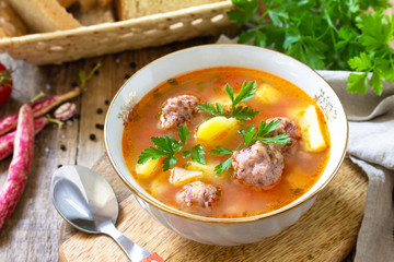 The concept of healthy and diet food, vegetarian dish. Delicious Vegetable soup with bean balls on a rustic table.