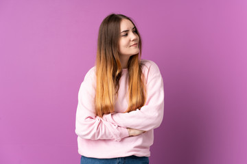 Obraz premium Young caucasian woman isolated on purple background looking to the side