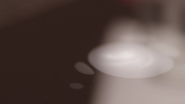 Spreading white paint on black on water ebru