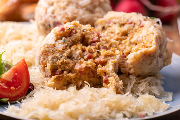 two speckknoedel with sauerkraut on wood