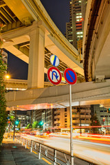 Road sign with a multilevel stack interchange in Shinjuku district, Tokyo