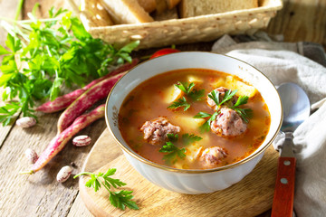 The concept of healthy and diet food, vegetarian dish. Delicious Vegetable soup with bean balls on a rustic table. Copy space.