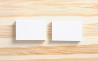Blank business cards stack on wooden background as template to showcase your presentation.