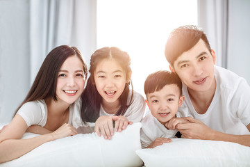 Happy family lying on  bed together in the bedroom