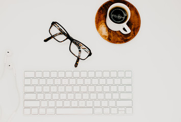 Flay lay of a white keyboard, with coffee and accessories for business advertisement
