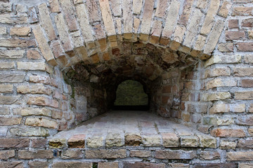 Small window embrasure in the old ancient historical brick wall.