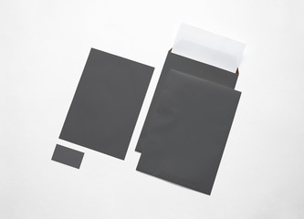 Empty black paper envelopes, letterheads and card isolated on white. 3d illustration.