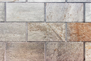 Texture of wall made of large brown textured stone bricks.