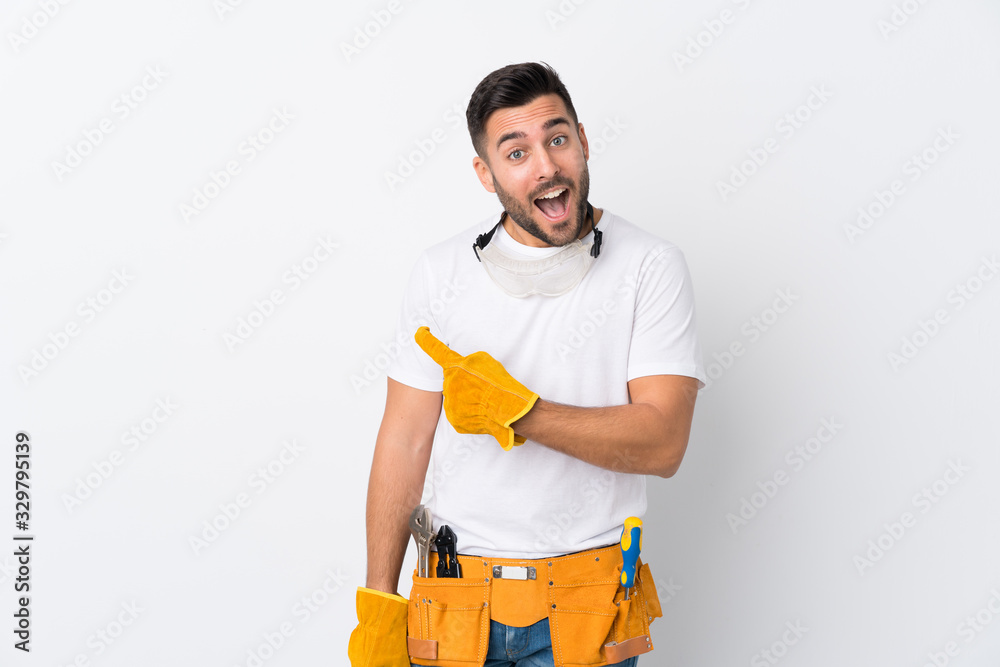 Wall mural craftsmen or electrician man over isolated white background pointing finger to the side