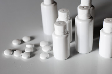 White vials and jars for medicines and tablets on a white background. Medicine. Virus. Antibiotics