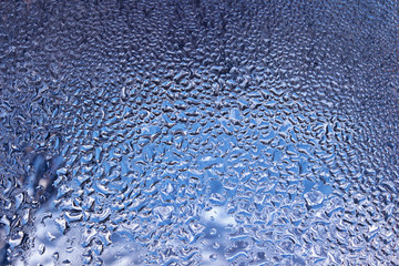 water drops on window glass with blue day shy background
