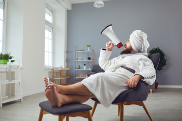 Funny pedicure beauty mask cosmetology concept. Funny fat man in a bathrobe shouts through a megaphone in room salon - obrazy, fototapety, plakaty