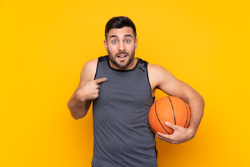 Obraz premium Handsome young basketball player man over isolated white wall with surprise facial expression