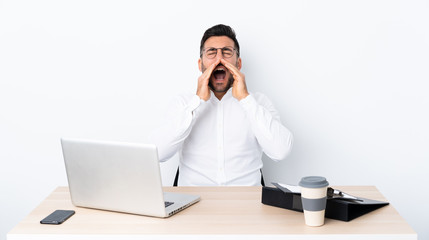 Young businessman in a workplace shouting and announcing something