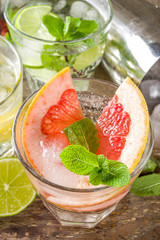 Summer detox beverage  concept. Citrus fruit drinks with ice. Healthy diet cocktail with making bar tools.  Vitamin fortified water