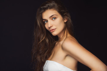 Naklejka premium Beautiful laughing brunette model girl with long curly hair . Smiling woman hairstyle wavy curls