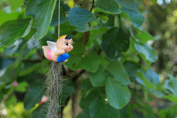 Clay doll hanging with green tree background