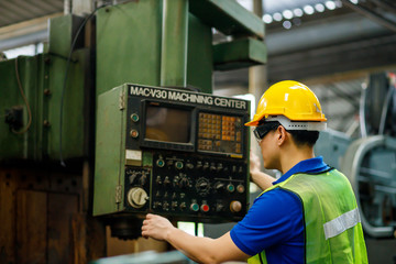 Asian maintenance engineers discuss inspect relay checking information and protection system on a tablet computer in a factory. They work a heavy industry manufacturing factory.