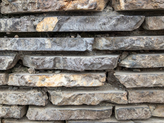 The surface of a stone wall. Masonry walls of old stone blocks.