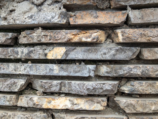 The surface of a stone wall. Masonry walls of old stone blocks.