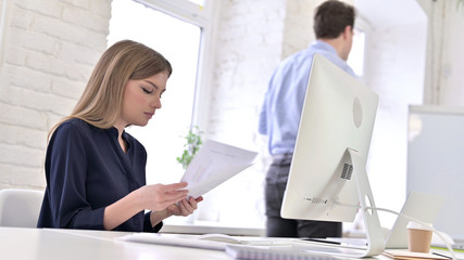 Obraz na płótnie Canvas Man Leaving Office while Woman Working on Desktop