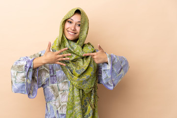 Indian woman isolated on beige background counting seven with fingers