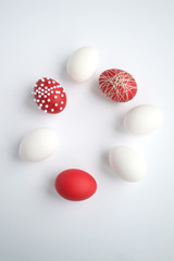 white and red easter eggs laid out in a circle on a white background