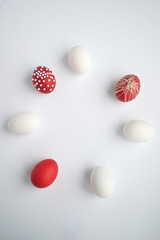 white and red easter eggs laid out in a circle on a white background