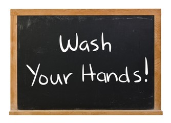 Wash your hands written in white chalk on a black chalkboard isolated on white