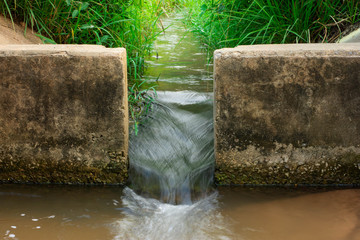 Water flows through the floodgate in the irrigation canal quickly.Water management, irrigation system, irrigation dam, irrigation canal To send to agricultural plots. To solve drought in northeast