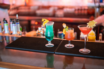 Colorful cocktails on the bar counter, party night out background. Cocktails drinks on the bar