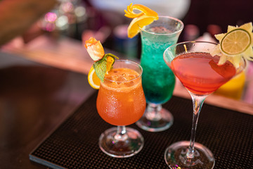 Colorful cocktails on the bar counter, party night out background. Cocktails drinks on the bar