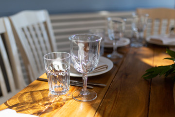 Glasses, forks, knives, plates on a table in restaurant served for dinner. Set dining table in loft style