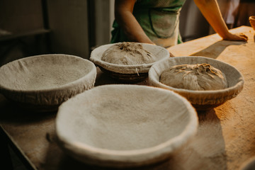 hands kneading bread dough on a cutting board