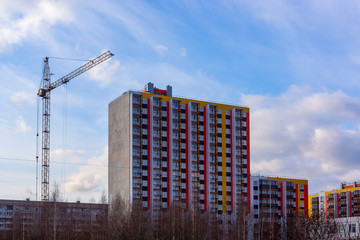 Fototapeta na wymiar Urban landscape of new cheap panel buildings and construction crane