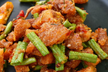 spicy stir fried crispy pork crackling with chili and ginger on plate