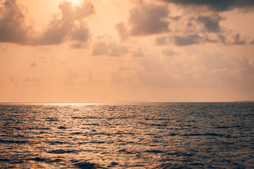 Fototapeta premium Peaceful seascape, tropical sea sunset with orange sky and clouds. Calm sea sunset