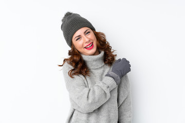 Young Russian woman with winter hat over isolated white background celebrating a victory