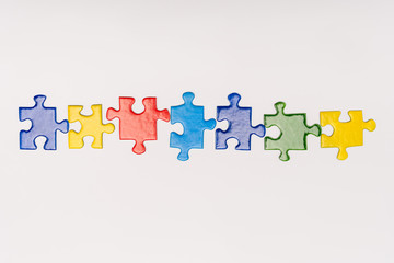 Top view of multicolored pieces of puzzle isolated on white, autism concept