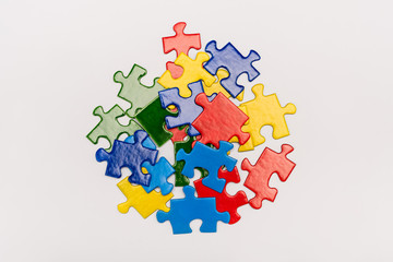 Top view of bright multicolored pieces of puzzle isolated on white, autism concept