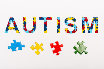 Fototapeta premium Top view of Autism puzzle lettering on white