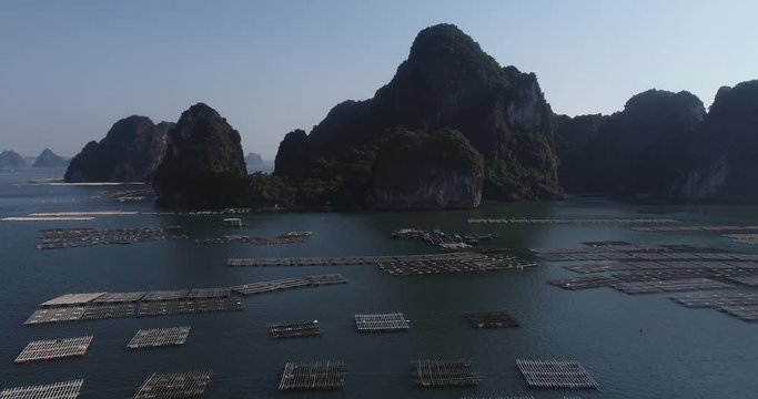 Aerial view of free stock footage over natural rocks green tops Bai Tu Long bay floating fishing village, sea blue azure water. Near Halong bay. Asia, Vietnam