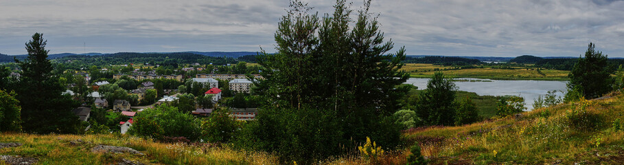 Obraz na płótnie Canvas Panorama of Karelian nature from a height.Panoramic view of the surroundings of Sortavala from a hill in a city park: a forest of conifers, traces of volcanic lava, rocks and volcanic rocks. Russia