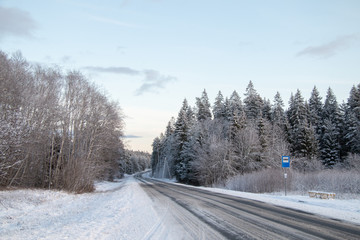 Winter country road and a bus stop in snowy winter day