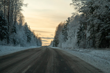 Obraz premium Winter country road in snowy winter day at sunset