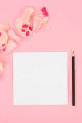 Composition with beautiful petals and notebook on color background. Wish list concept