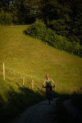 Fototapeta premium Handsome young man biking on a mountain bike enjoying healthy active lifestyle outdoors in summer (shallow DOF)