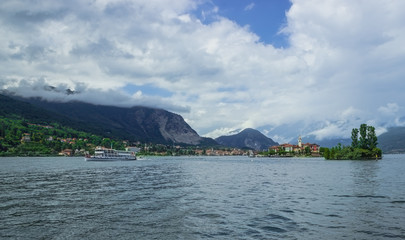 Beautiful view from the Isola Bella embankment . Isola Dei Pescatori and the passing ship. Soft focus, blurry background.