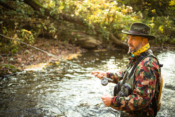 Fly fisherman fly fishing on a splendid mountain river