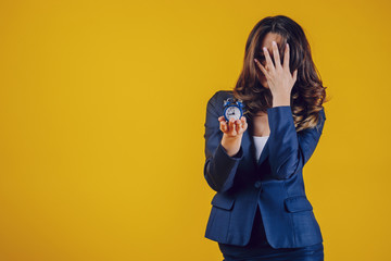 The American woman dressed elegantly as a teacher or business lady, holds a watch in her palm and...